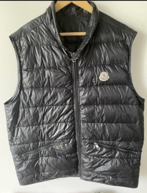 Moncler väst Gui  - Moncler väst i bra skick! Storlek 4 (L/XL Färg navyblue Ända defekten är dragkedjan som ni ser på bilden.  Inga tillbehör tillkommer