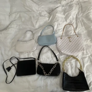 Väskor - Alla väskor för 150kr. Väskor från ginatricot, h&m och shein. Svarta väskan med guldband, svarta väskan med långt band, vita stora väskan och den blåa är aldrig använda.