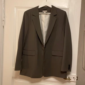 Kavaj  - Snygg mörkgrön/ olivgrön kavaj, går att använda till både vardags och fest.  Lagomt oversize!  Går att matcha till mycket. Från kostymbyxor till jeans.  Använd endast en gång.  Köpt från hm (original pris 450kr), finns ej att köpa längre.  Först får den!