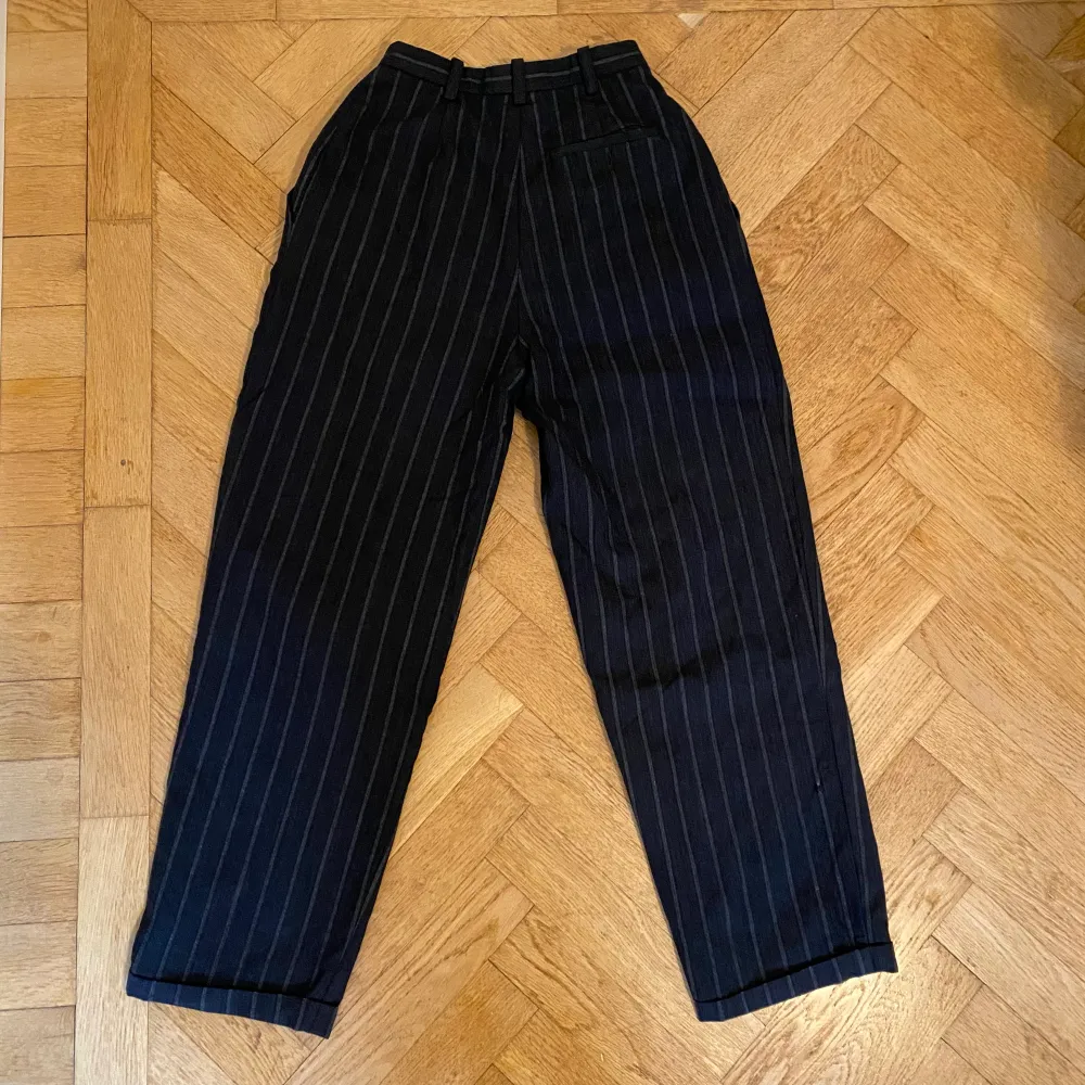 Grå randiga kostymbyxor köpta second hand.  midja: 66 cm  innerbenslängd 70 cm. Jeans & Byxor.