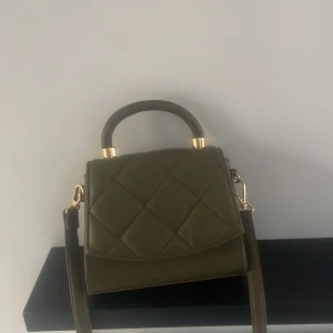 Grön väska  - Aldrig använd väska, ca 18 cm bred och 15 cm längd 