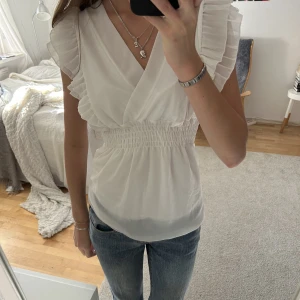 Vit volangblus - (Återpublicerar för fri frakt) jättefin vit blus med smock och volangärmar!