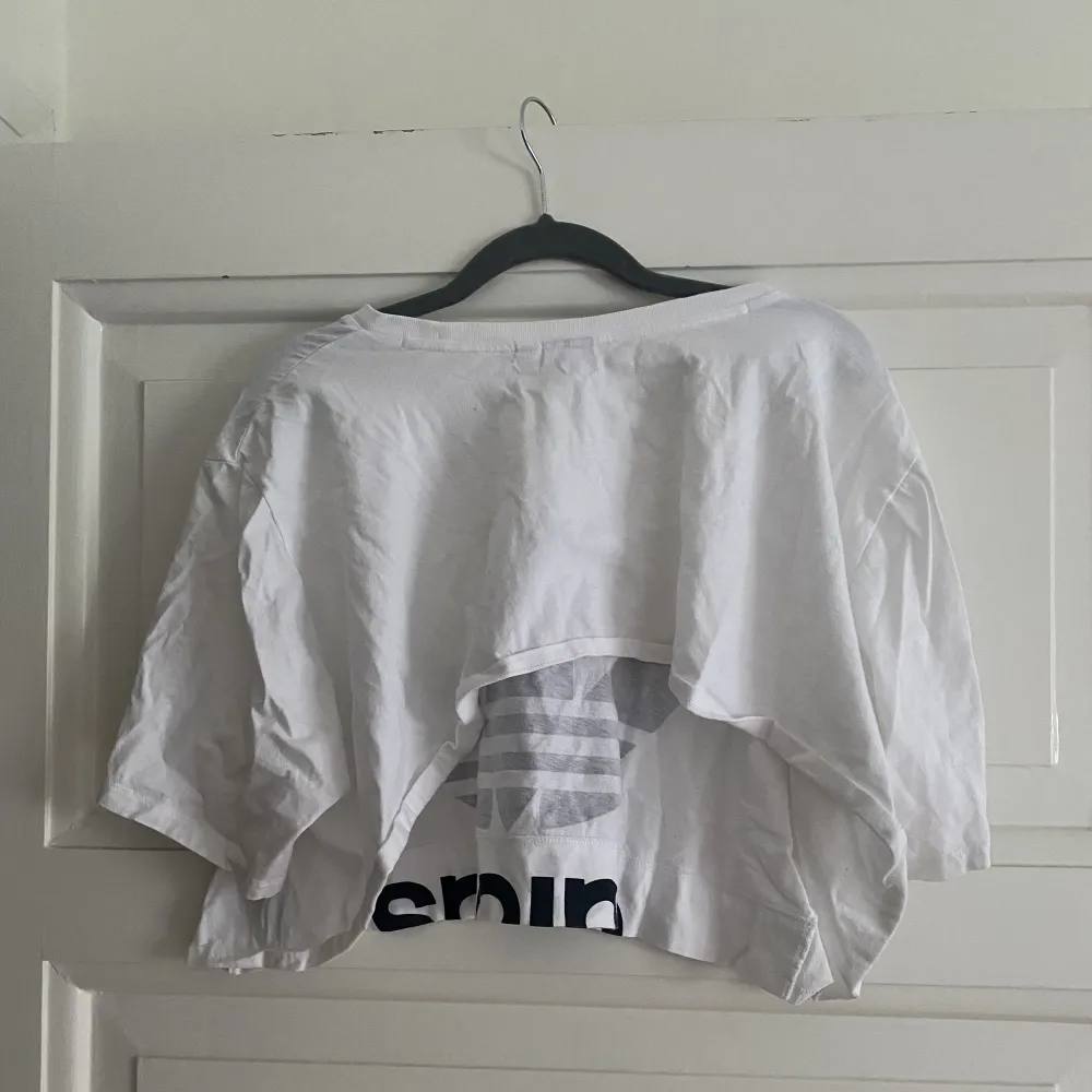 En vit croptop med den klassiska adidasloggan i storlek L. T-shirts.