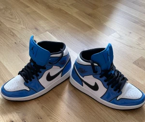 Jordan 1   - Detta är ett par fina Air Jordan 1 Mid SE signal blue, storlek 41. Skorna är i bra skick 7.5/10.  Priset kan diskuteras vid snabb affär. 
