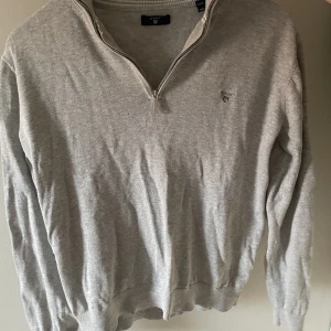  Halv zip tröja Gant - En grå stickad tröja från Gant med halv zip. Använd ett par gånger och skicket är 8/10 Pris kan diskuteras vid snabb affär