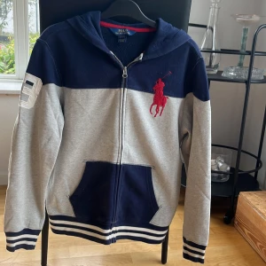 Huvtröja Polo Ralph Lauren - Autentisk hoodie från Ralph Lauren i gott skick, liten fläck på vänster arm uppe (fråga om bild). Kan passa någon som bär S och Xs. Pris kan diskuteras. Köparen står för frakten. Säljs pga för liten.