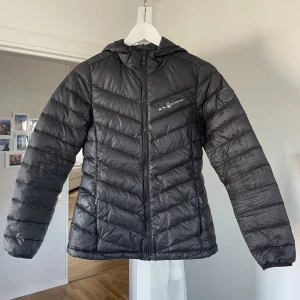 Sail Racing dunjacka - En svart klassisk dunjacka från Sail Racing🛍️ Välanvänd och har en liten defekt på framsidan annars okej skick🌟 Lite tunnare dun på vissa ställen och pris kan diskuteras!