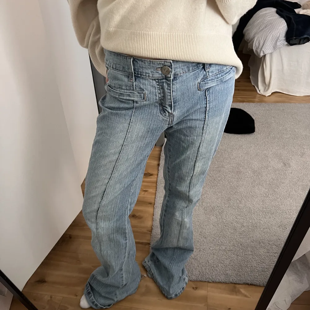 Lågmidjade ljusblå bootcut jeans  med en söm på bak-och framsida. Innerbensläng: 81cm Midjemått: 38.5 cm rakt över . Jeans & Byxor.