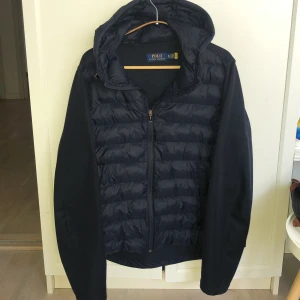 Polo Ralph Lauren jacka - Polo Ralph Lauren jacka i mörkblå färg, helt okej skick, står att den är i storlek XL men passar M och S också, priset går att diskuteras för snabb affär! Lite defekter på dragkedjan men annars inga skador