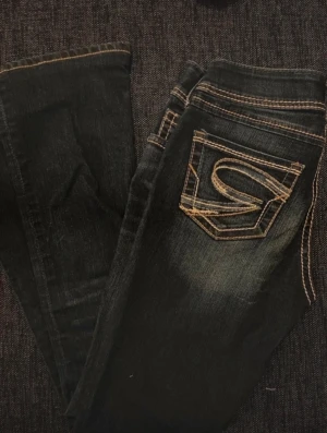 Lågmidjade jeans - Lågmidjade bootcut jeans med snygga sömmar! Storlek XS men materialet har lite stretch och kan passa större storlekar. Oanvända med prislappen kvar. Kontakta för fler bilder💓