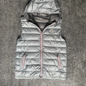 Moncler väst  - säljer nu denna moncler västen då den börjar bli liten fint skick! Storlek 14y skulle säga passar perfekt på någon på ca 170 skulle säga 165-175 beroende på vikt