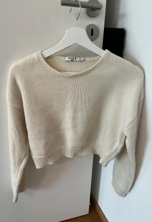 Söt stickad korttröjs - Vit/natur-färgad stickad kirttrlja från NA-KD. 