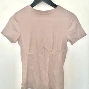Tight, ljusrosa T-shirt med smickrande söm under bysten. Passar strl 36-38. Kan ta fler bilder ifall det önskas! 🌻