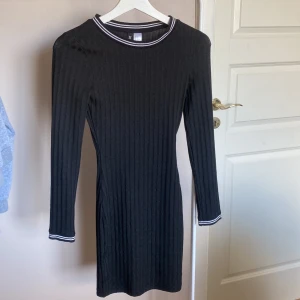 Svart klänning - En jättefin svart klänning med vita ränder vid armar och hals från H&M i storlek 32. Sitter väldigt tight. Aldrig använt den så i väldigt bra skick💕