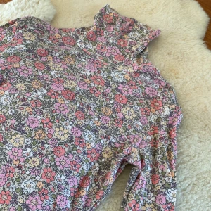 blommig body - en blommig body. polo. hål för tummarna. tunn och skön.