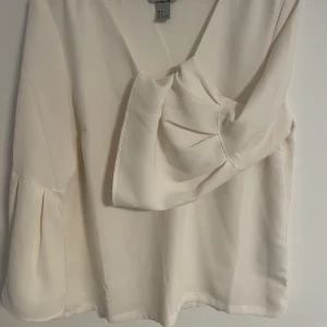 Hm blus  - Vit blus från hm, ballongärm som detalj och mjuk v ringad krage. Jag är 36-38 och den har passat mig perfekt! 