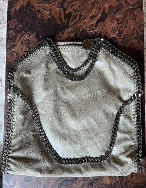 Oanvänd Stella McCartney Falabella Shaggy bag - Säljer min Falabella Shaggy Deer fold over tote i färgen kakhi/beige från Stella McCartney då jag har en till väska i samma modell som jag använder mer.  Denna har jag aldrig använt. Kommer med dustbag. Kvitto finns att få.