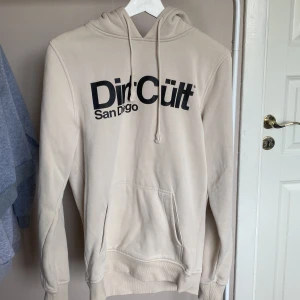 Dirtcult hoodie - En beige dirtcult hoodie i storlek S. För mig är den stor i storleken. Den är ganska använd men ändå i väldigt fint skick.💕