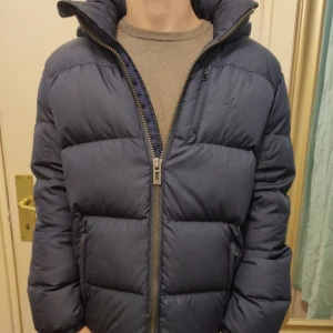 Ralph Lauren Jacka - Hej jag säljer min Polo Ralph lauren vinterjacka då jag köpt en ny. Nypris 2200, mitt pris 550. Defekter vid ena armen, se bild. Skriv för fler bilder eller funderingar.