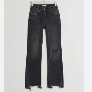 Urtvättade svarta jeans  - Säljer mina riktigt snygga trendiga flare jeans från Gina tricot med hål på ena knät. Dessa är helt slutsålda på deras hemsida och kommer nog inte tillbak.  Har klippt dom på längden en bit jag är 160/165 cm lång. Lånad bild skriv gärna för fler bilder💘🩵