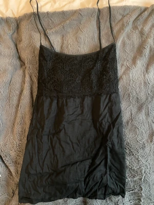 Svart spetsig topp - En svart spetsig topp från Gina Tricot i storlek 42. Aldrig använd.  