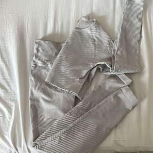 Träningsset med tights och croppad tröja från aim’n. Är använt några gånger, men är i bra skick! Endast tagen på byxan som lossnat på ena sidan. Grå/begie i färgen, storlek M i båda delarna.