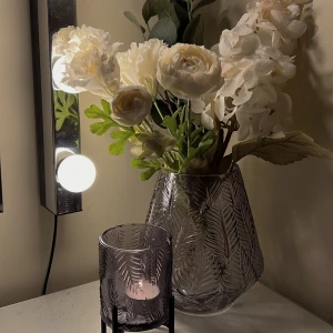 Vas + ljuslykta  - Vas och matchande ljuslykta 🕯️ I fint skick💐 Säljer båda för 70kr🌸 Färgen är vit/grå, materialet är glas Pm för fler bilder/frågor om mått