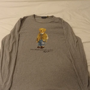 Polo Ralph Lauren (Polo Bear) XL Långärmad - Grå långärmad från Ralph Laurens polo bear kollektion storleken är L men den sitter som en XL, något använd men sitter fortfarande som den ska. QR koden sitter fortfarande kvar.