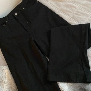 Highwaist jeans med slits - Ett par svarta highwaist jeans från DR DENIM. De är i storlek 28/34. Och i ganska nytt skick. Har endast använts ett par gånger.