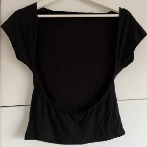 Tshirt med öppen rygg - Svart T-shirt med öppen rygg. Aldrig använd 