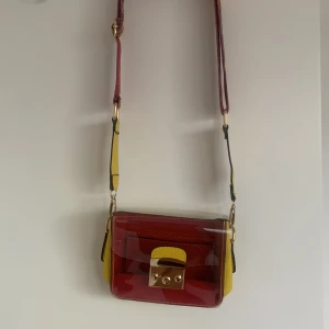 Liten väska - Säljer denna väska som jag köpte i Frankrike för något år sedan då den aldrig kommit till användning. Den har ett svagt märke på baksidan( syns på andra bilden) men det går säkert att få bort:)