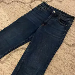 Säljer dessa jeans jag bara har använt runt 4 gånger. super fin mörkblå färg. dessa är mediumwaist bootcut stretch jeans. vart de kommer ifrån vet jag inte med de har slitningar i ändan av jeansen men de är så i själva modellen när man köper de från affär