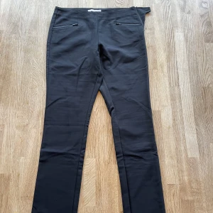 Svarta kostymbyxor Wera - Svarta, smala kostymbyxor i slimmad modell. Dragkedja i sidan.  Midjemått: ca 37 cm Innerbenslängd: ca 79 cm Säljes då de är något för små för mig. 