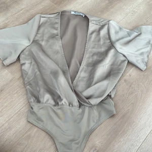 Wrap over short sleeve body - Fin body som passar till de mesta, aldrig använd.