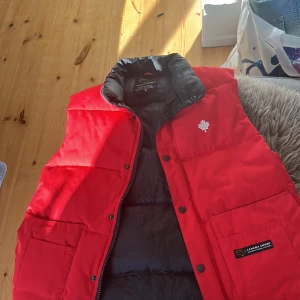 Canada goose väst - En röd canadagoose väst i bra kondition andvänd en del i väldigt bra skick inga skador vad jag har sett iaf