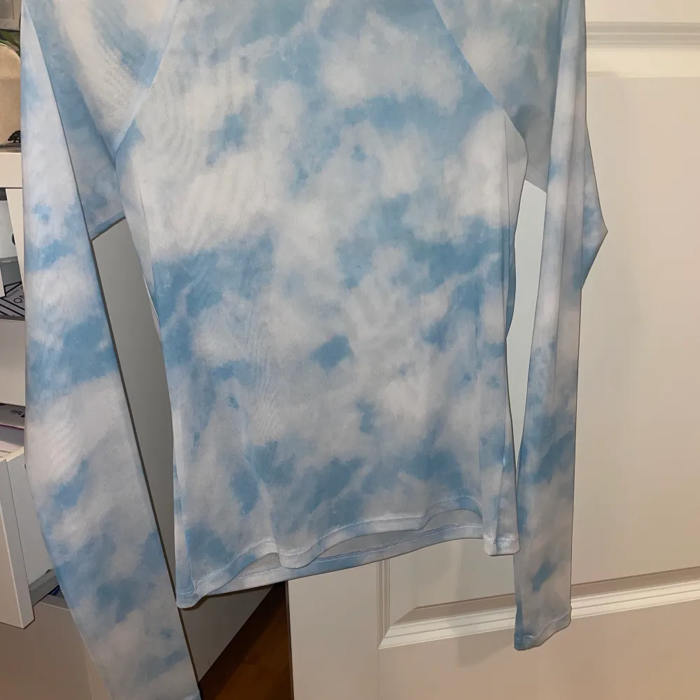 En superfin långärmad tröja i Mesh material. Fint mönster av ljusblå himmel med moln. Använt 1 gång. Finns inte att köpa längre på nätet. Långärmad storlek S. Väldigt skönt material. 💓. Toppar.