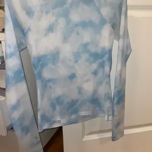 En superfin långärmad tröja i Mesh material. Fint mönster av ljusblå himmel med moln. Använt 1 gång. Finns inte att köpa längre på nätet. Långärmad storlek S. Väldigt skönt material. 💓