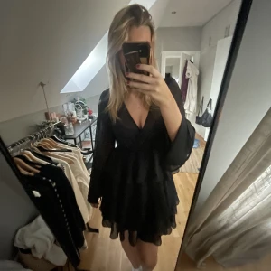 Svart volangklänning - Supersöt klänning från NAKD, passar perfekt nu till jul och nyår. Säljs då jag inte har användning för den längre. Toppen skick🙌🏼 Nypris kring 400kr ❤️