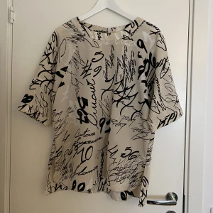 Fin oversized blus från River Island storlek 42 - Jättefin kortärmad blus från River Island i storlek 42. Passformen är oversized.  Färgen är nude, rosa, beige, svart och vit. Mycket fint skick! Som ny! Använd endast tre gånger! Nypris 549kr!