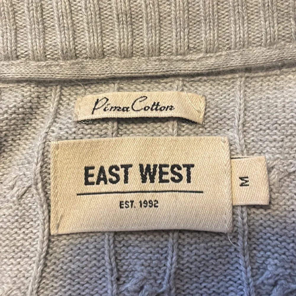 En grå Kabelstickad tröja från East west. Tröjan är i utmärkt skick och har inga hål eller andra defekter. Den är i storlek medium. Perfekt nu till vintern. Hör av dig för fler bilder eller frågor.. Stickat.