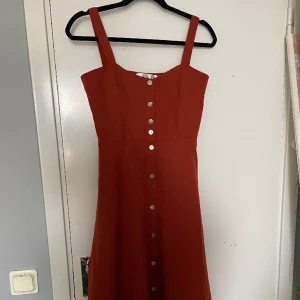 Orangeröd långklänning - En lång klänning som är perfekt för layering. Jag skulle uppskatta att den är i storlek 36.