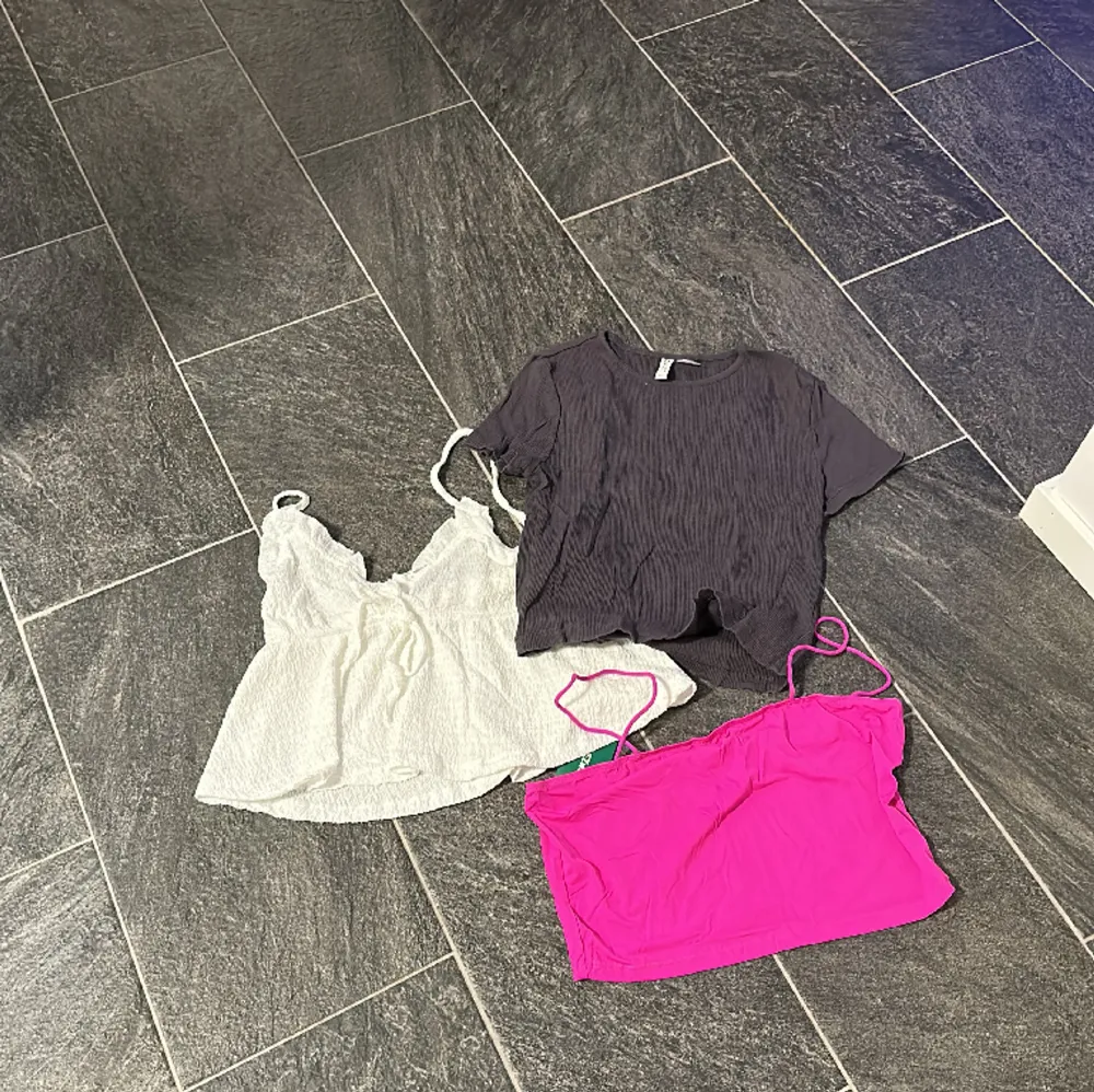 Ett klädpaket med ett neonrosa linne, en T-shirt från hm och en blus . Blusar.