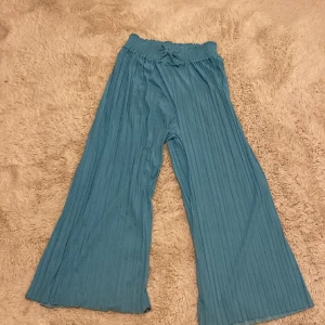 Fladder byxor! - Fladdriga turkosa byxor! Det är 13-14 år men dem är ganska korta.