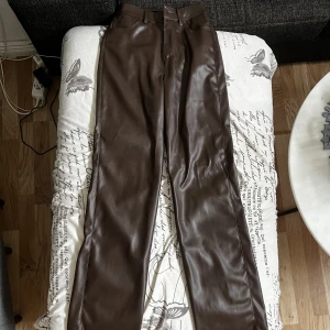 Skinnbyxor - BikBok - Bruna högmidjade skinnbyxor i storlek 34 från BikBok. Använda fåtal gånger så därför i väldigt gott skick. 
