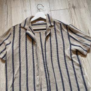 Randig kortärmad skjorta från Zara! Väldigt härlig och enbart använd en gång. (Obs: liten i storleken, sitter mer som en M)🤍🤎