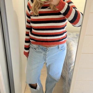 Randig stickad tröja - Stickad tröja från varumärket Minimum i ett randigt mönster i färgerna orange, vit, och marinblå💙🤍🧡 Metrialet är i wool! Perfekt till vardags nu i höst!! 