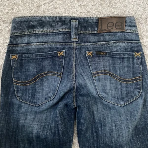 Lågmidjade Lee jeans - Supersnygga lågmidjade Lee jeans. Säljer pga att de tyvärr är för små för mig i midjan. Jag har aldrig användt dem men de är köpta secondhand så det kan finnas tecken på användning. Midjemåttet är 34cm rakt över. Innerbenslängden är 80cm💕💕💕💕