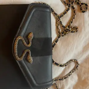Jättesöt väska. Med en cool detalj med en orm. Perfekt när man ska ha med sig typ mobil eller börs.