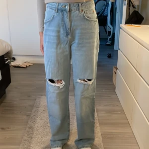Blåa håliga jeans  - Blåa håliga baggy jeans, aldrig använda, gula sömamar från bikbok