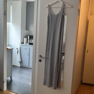 Klänning - Figursydd långklänning i lent och skönt material väldigt fin till sommaren. Har en slits vid vänstra benet. Säljer då den har blivit liten för mig. 